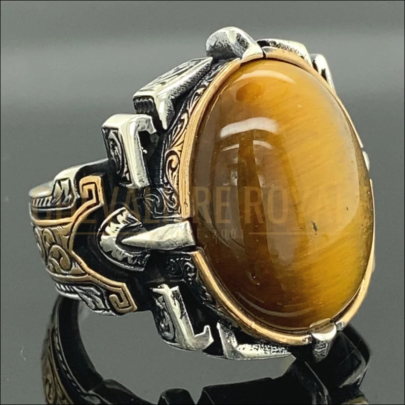 Optez pour la sophistication avec notre chevalière en argent massif, mettant en avant une pierre œil de tigre de 15 x 20 mm. Cette bague artisanale, réalisée à la main, combine une forme ovale élégante à des vertus protectrices et énergétiques. Parfaite pour un cadeau unique ou pour ajouter une touche distinctive à votre collection de bijoux, elle offre un mélange de style et de signification profonde.-Chevaliere Royale-