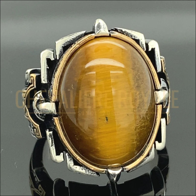 Optez pour la sophistication avec notre chevalière en argent massif, mettant en avant une pierre œil de tigre de 15 x 20 mm. Cette bague artisanale, réalisée à la main, combine une forme ovale élégante à des vertus protectrices et énergétiques. Parfaite pour un cadeau unique ou pour ajouter une touche distinctive à votre collection de bijoux, elle offre un mélange de style et de signification profonde.-Chevaliere Royale-854